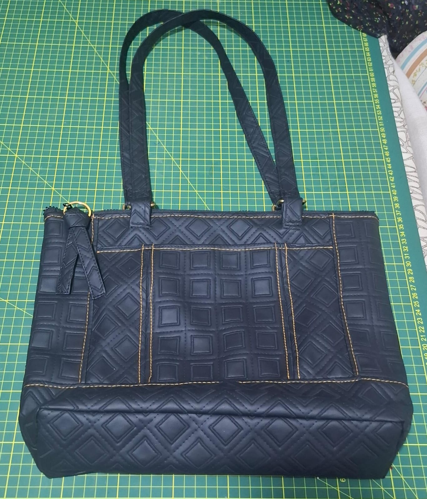 Cartera negra en cuerina con costura en rombos y dos asas