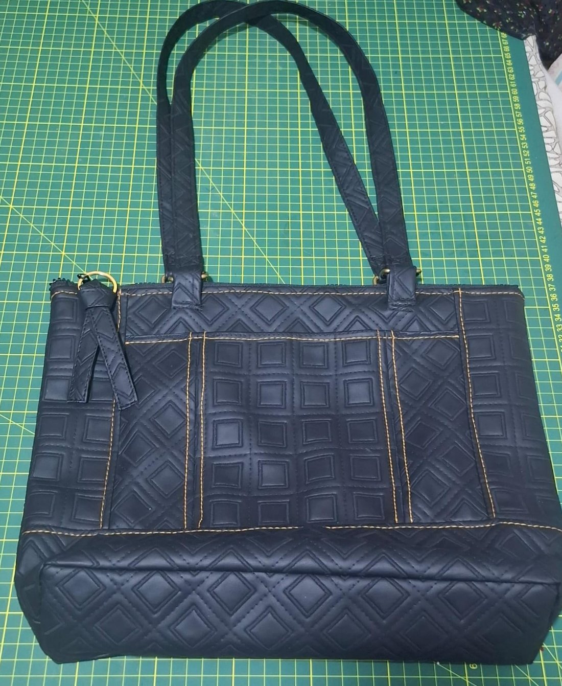 Cartera matelassé negra con pespunte dorado, hecha a mano en el taller de Akat