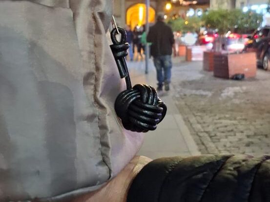 Llavero de nudo de cuero colgado de un bolso en la calle de noche